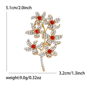 Elegant gold-tone flower brooch with white and red crystals measuring 5.1cm by 3.2cm