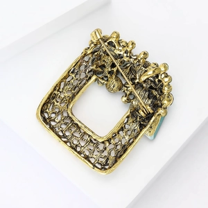 Detailed back view of vintage hollow square brooch with antique gold finish and pin clasp