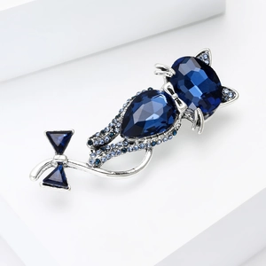 Macro shot of blue crystal cat brooch with detailed silver metal and ribbon tail
