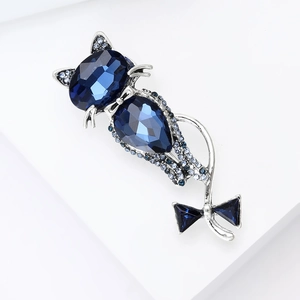 Detailed macro view of the silver cat brooch with deep blue crystals and rhinestones
