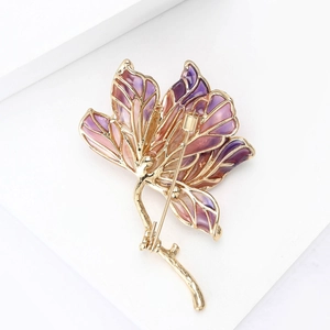 Dettaglio della spilla a fiore con petali in smalto viola e chiusura rotante dorata sicura