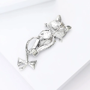 Detailed back view of the cat brooch showing the silver metal pin clasp and vintage texture