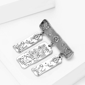 Macro-opname van een vintage zilveren etnische broche met gegraveerde tribale vogelpatronen