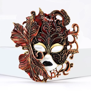 Detail of venetian style carnival mask brooch with enamel finish and gold leaf texture