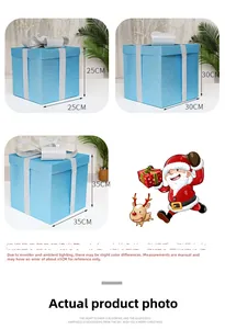 Three sizes of blue glitter Christmas gift boxes with silver bows for festive window display