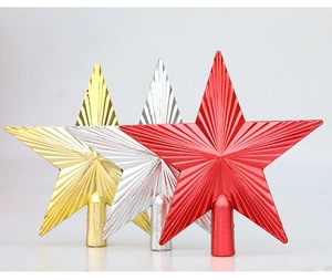Close-up of gold, silver, and red star tree toppers with textured radial grooves