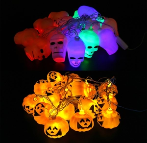 Macro shot of Halloween LED string lights featuring colorful skulls and glowing pumpkins
