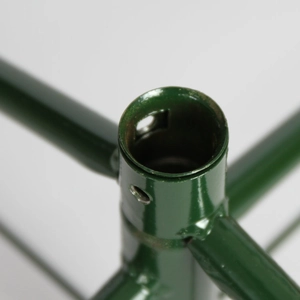 Detail of green metal Christmas tree stand with three-way connector and screw hole