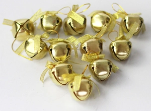 Set of small golden Christmas bells with sheer gold ribbons on a white background