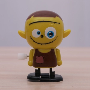 Funny yellow monster wind-up toy with Frankenstein stitch design and big round eyes