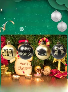 Close-up of black and gold Christmas ornaments with 2021 Happy College Grad lettering