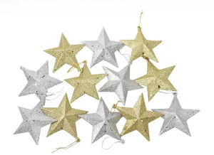 Close-up of glittery gold and silver Christmas star ornaments with hanging strings