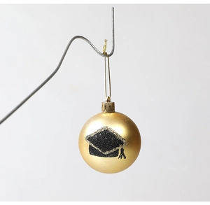 Matte gold graduation ornament featuring a black glitter mortarboard cap design