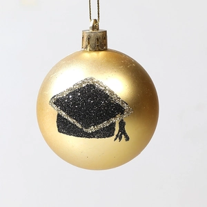 Golden graduation ball ornament featuring a black glitter mortarboard design for tree decor