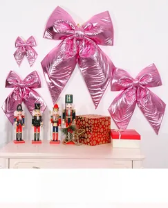 Détail de nœuds décoratifs en tissu métallique rose brillant en tailles assorties sur mur