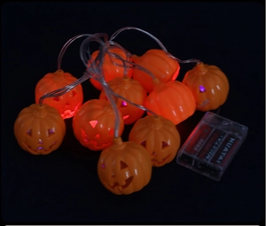 Detail of Halloween LED pumpkin string lights with hollow faces and clear battery box
