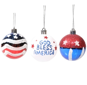 Close-up of three patriotic Christmas ball ornaments with God Bless America text and glitter