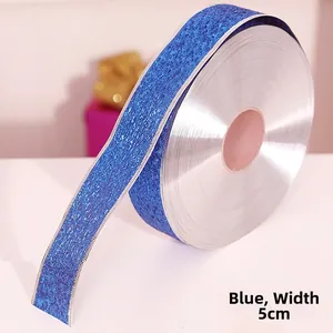 Close-up of 5cm wide blue glitter ribbon roll with silver edges for Christmas decor