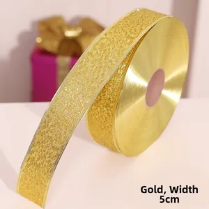 Detailed macro of 5cm wide gold glitter ribbon roll for festive gift decoration