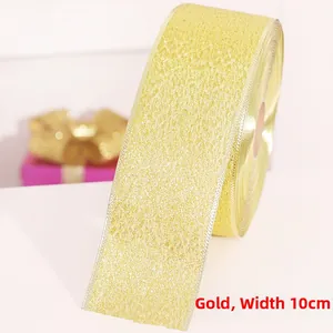 Close-up of 10cm wide sparkling gold glitter ribbon with elegant silver metallic edging