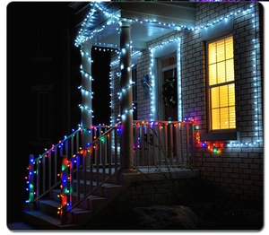 Macro detail of multicolored LED string lights wrapped on house railings at night