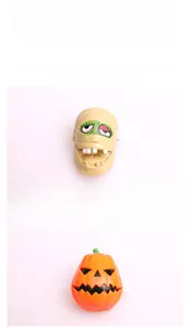 Detail of Halloween wind-up toys showing mummy head and orange pumpkin with vivid patterns