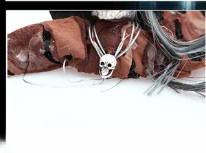 Detail of hanging Halloween skull ornament with silver metallic finish and textured fabrics