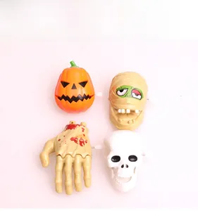 Close-up of Halloween wind-up toys including pumpkin, mummy, ghost hand and skull