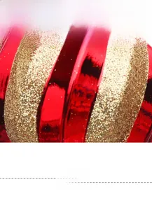Detail of red and green striped Christmas ball with shimmering gold glitter powder coating