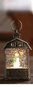 Detail view of a bronze Christmas lantern with a snowman and swirling glitter water