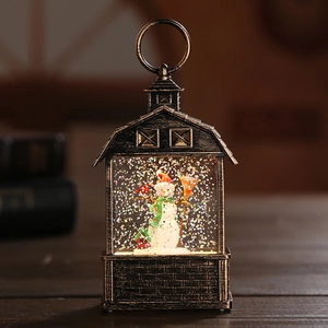Close-up of vintage bronze snowman snow globe lantern with swirling glitter and warm light