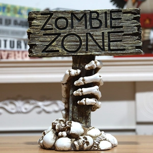 Detail of resin skeleton hand holding a Zombie Zone sign with skull pile base