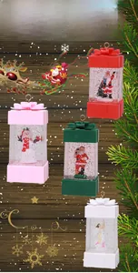 Detailed view of Christmas snow globe ornaments in festive gift box shapes with figurines