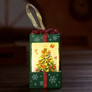 LED Christmas gift box light with green body, red bow, and festive tree motif hanging ornament