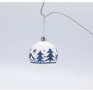 Gros plan d'une boule de Noël blanche mate avec forêt de paillettes bleues et fil argenté