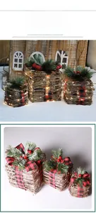 Detailed close-up of three lighted wicker Christmas gift boxes with red plaid bows and LED lights