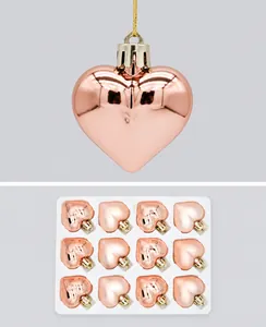 Detail of rose gold heart-shaped ornaments with reflective mirror finish and gold strings