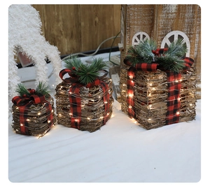 Detail view of woven rattan Christmas gift boxes with plaid bows and warm LED lights