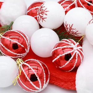 Assorted red and white Christmas baubles with stripes and snowflakes on pine branches