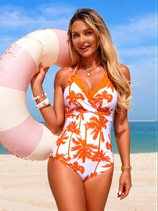 Detail of white one-piece swimsuit with orange palm print and scalloped halter neckline
