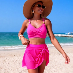 Close-up of rose pink two-piece bikini featuring twist-front top and side-tie swim skirt