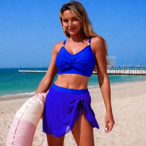 Three-piece royal blue bikini set with twist-front halter top and chiffon wrap skirt