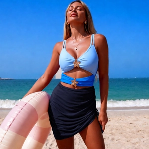Detailed view of the blue three-piece swimsuit featuring elegant golden flower buckles