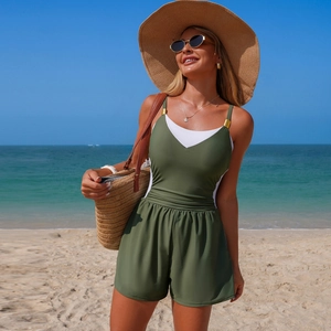 Detail view of olive green one-piece swimsuit with straps and waist pleats on beach