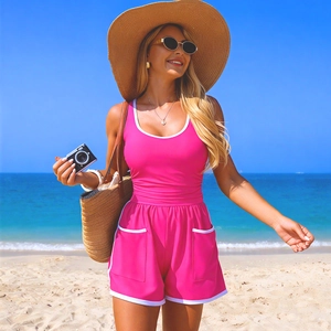 Maillot de bain sport rose vif avec liseré blanc et short taille haute sur la plage