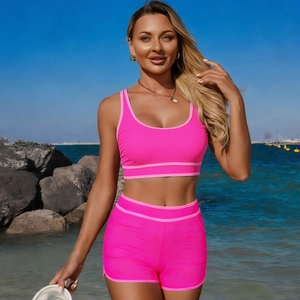 Dettaglio bikini sportivo rosa vivace a due pezzi su sfondo di spiaggia soleggiata