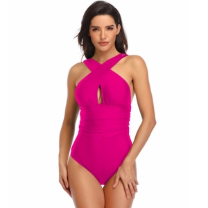 Detail of magenta one-piece swimsuit featuring crossover halter neck and ruched waist