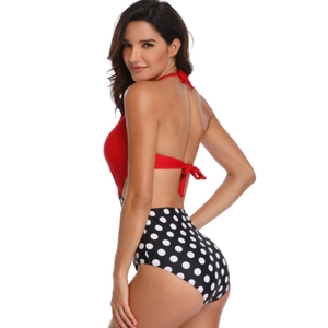 Detail of red halter neck swimsuit with black and white polka dot high waist bottom