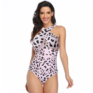 Close-up of pink cow print one-piece swimsuit with crisscross neck and waist pleats