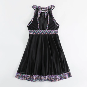 Flat lay of black halter neck swimsuit featuring colorful geometric wavy prints and mesh skirt